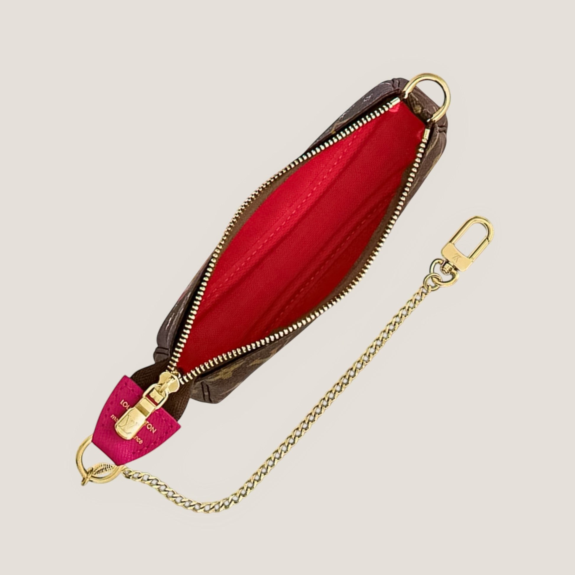 EDIT8 COLLECTIVE Louis Vuitton Mini Pochette Accessoires Vivienne in Switzerland limited edition pouch with brown monogram canvas, red interior, and gold-tone chain.