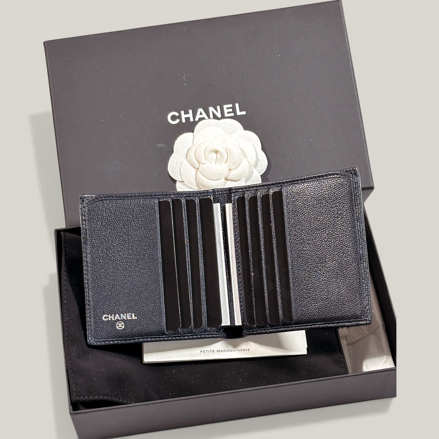 EDIT8 COLLECTIVE Chanel black caviar leather bifold wallet with multiple card slots and bill compartments.