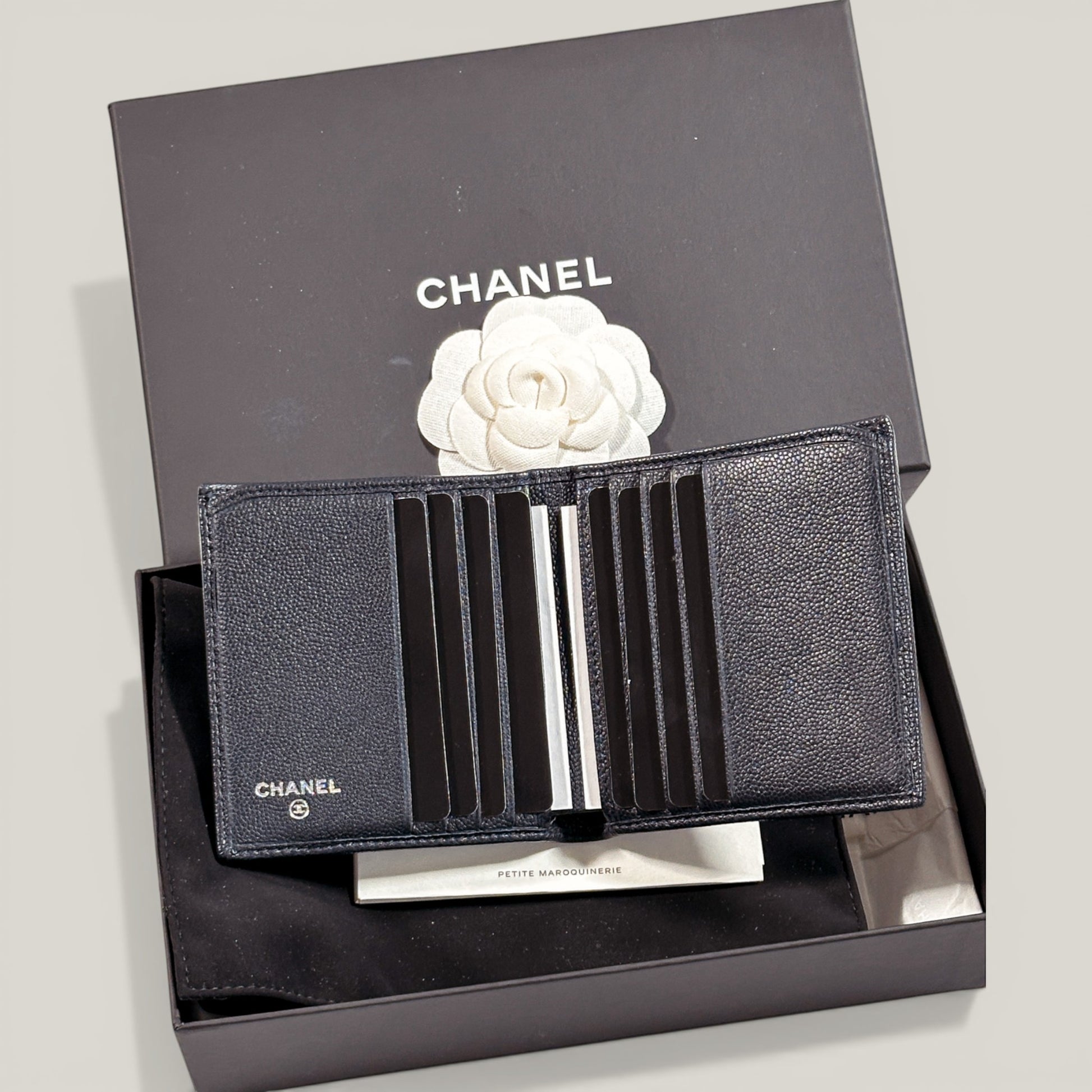 EDIT8 COLLECTIVE Chanel black caviar leather bifold wallet with multiple card slots and bill compartments.